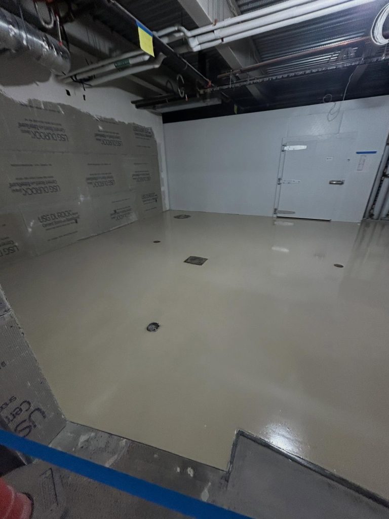 Commercial epoxy install in progress, wet white basecoat with USG Durock walls