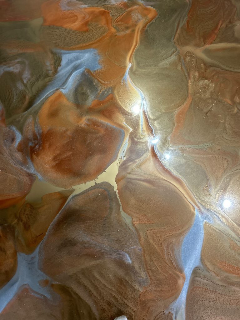 Metallic epoxy close-up macro showing copper and orange swirl